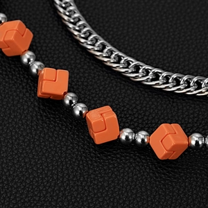 Close-up of a double-layered street style pants chain with orange cube beads and silver link