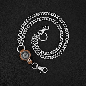 Détail macro d'une chaîne motard argentée avec mandala gravé sur base en cuir brun