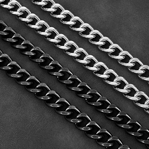 Detail of silver and gunmetal chunky cuban links over dark textured leather