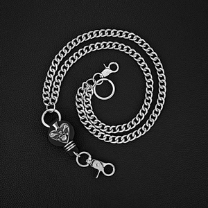 Détail d'une chaîne de pantalon punk en métal argenté avec pendentif tête de mort et cœur
