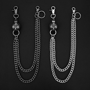 Détail des doubles breloques crâne punk et des chaînes lourdes sur cuir noir