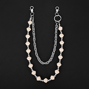 Close-up of double-layered pants chain with white resin paw beads on black leather background