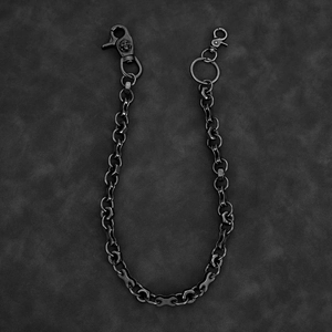 Macro detail of industrial skull clasp and nut chain on dark leather background