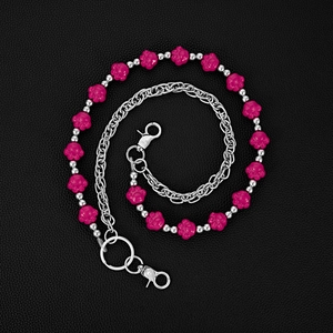Detail of pink resin bear paw beads and silver metal chain link on black background