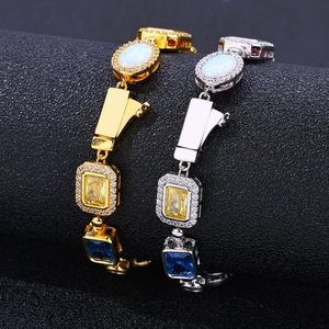 Hip hop style gold and silver bracelets with opal, yellow and blue gems on black stand