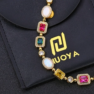 Détail de bijoux de luxe avec opales et rubis colorés sertis de zircons dorés