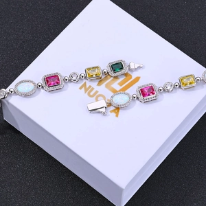 Bracelet luxueux en argent avec zircons colorés et pierres opales sur boîte blanche