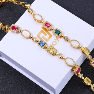 Gros plan du collier en or avec pierres précieuses colorées et opale blanche en coffret