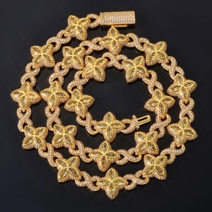 Detailed close-up of golden Cuban chain featuring clover motifs with marquise-cut yellow gems