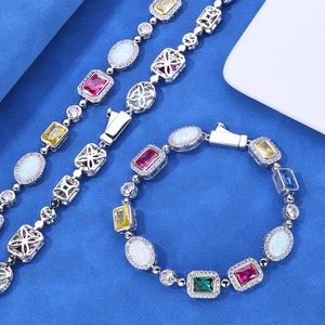 Macro detail of silver bracelet featuring colorful gemstones and white opal settings