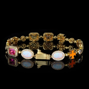 Detail van een gouden kettingarmband met roze edelsteen, opaalstenen en oranje kruis