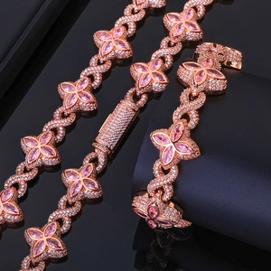 Macro detail of rose gold Cuban link bracelet with pink clover gems and white zircons