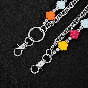 Detail of multi-layer trousers chain featuring colorful bear paw charms on metal links