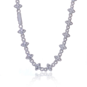 Macro detail of S925 silver Cuban chain with infinity links and moissanite clover design
