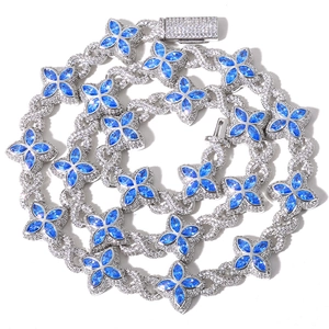 Detail of silver Cuban chain necklace with blue clover gems and sparkling zircon stones