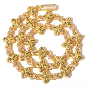 Detailed close-up of hip-hop Cuban chain with clover motifs and yellow gemstones