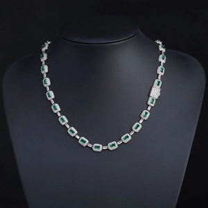 Detailed close-up of S925 silver necklace with emerald cut green gemstones and pavé accents
