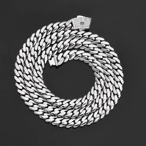 Macro detail of silver Cuban link chain with a sparkling diamond-set S logo safety clasp