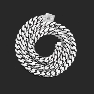 Detail shot of chunky silver Cuban link necklace with micro-pave diamond S-logo clasp