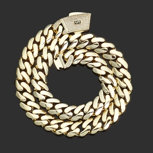 Macro shot of 14K gold-plated Cuban link chain with iced-out pave rhinestone clasp