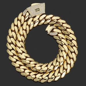 Close-up of 14K gold cuban link necklace with a diamond-encrusted square clasp and S logo