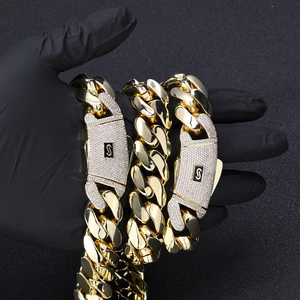 Détail de la chaîne cubaine en or 14 carats avec boucle logo S sertie de zircons