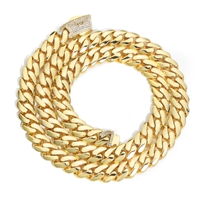 Macro detail of 14k gold-plated Cuban link chain with micro-pave zircon box clasps