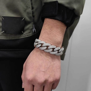 Detail view of 20mm iced out Cuban link bracelet with micro pave zircons on male wrist
