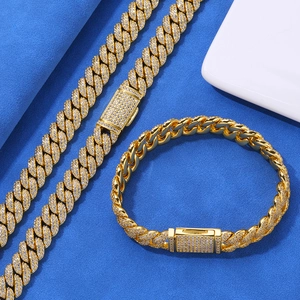 Dettaglio di bracciale e collana Cuban hip-hop dorati con zirconi incastonati su blu