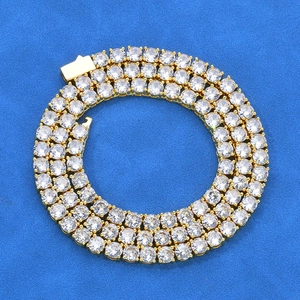 Detailed top view of gold tennis necklace with round-cut stones on blue textured background