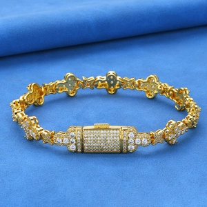 Vue détaillée des maillons de bracelet trèfle doré avec zircons sertis de pavés