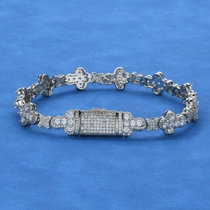 Détail d'un bracelet argenté trèfle et étoile serti de pierres de zircone cubique