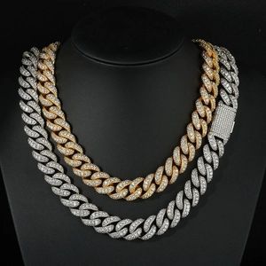 Detailed close-up of iced-out gold and silver Cuban link necklaces with zircon stones