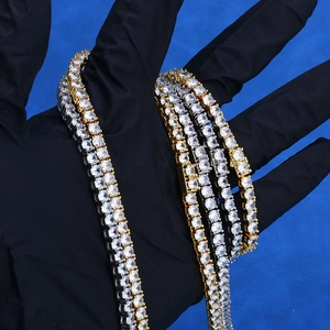 Detailed close-up of gold and silver hip hop tennis chains with round-cut cubic zirconia