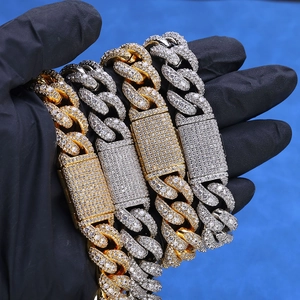Macro shot of silver and gold iced-out Cuban link chains with Moissanite stones
