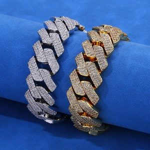 Detalle de pulseras cubanas de hip-hop doradas y plateadas en un soporte de joyas