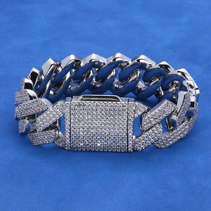 Detalle de pulsera de cadena cubana de 20mm con moissanita densa sobre terciopelo azul