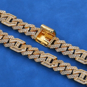 Luxurious 15mm golden Cuban link bracelet with sparkling zircons on blue velvet background