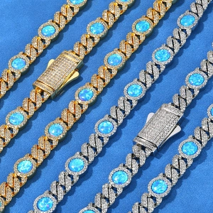 Iced out gold and silver Cuban link necklaces with blue opal stones on blue background