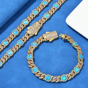 Détail de l'ensemble chaîne cubaine dorée 8mm avec opales bleues et zircons étincelants