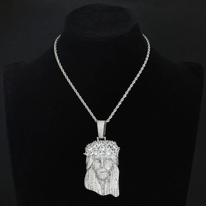 Détail du pendentif tête de Jésus argenté serti de zircons sur une chaîne corde