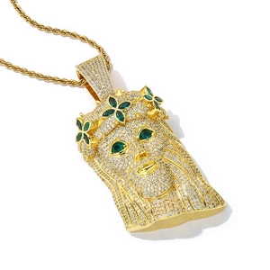 Detail of gold-plated Jesus head pendant with sparkling white and green cubic zirconia