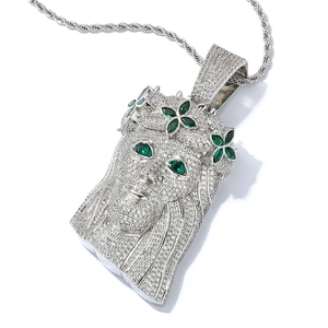 Detailed close-up of silver Jesus portrait pendant with full zircon and green gemstones