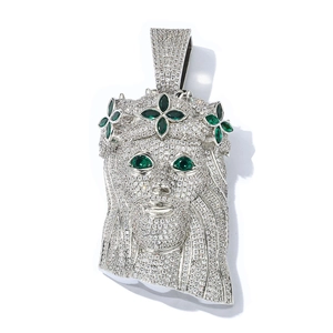 Macro detail of iced out silver Jesus pendant with green zircon eyes in hip-hop style