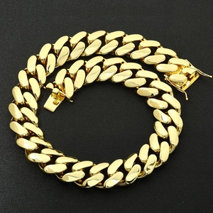 Close-up of polished golden cuban link necklace with secure box clasp on black background