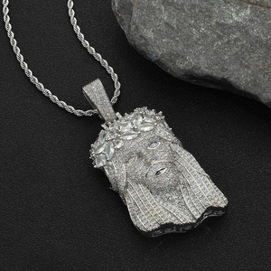 Vue macro du pendentif Jésus argenté serti de zircons avec une grosse chaîne corde