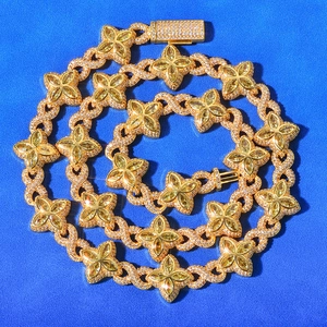Macro view of gold-plated clover links with yellow gemstones and zircon pavé detailing