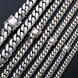 Polished silver Cuban link chains in six various widths displayed on a black surface
