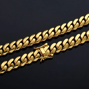 Macro shot of polished gold Cuban link chain showing the detailed box clasp and security lock