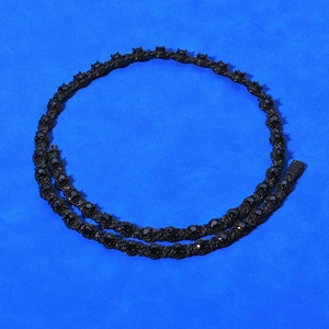 Detail of 7.5mm black zircon tennis chain with high-gloss plating on blue fabric